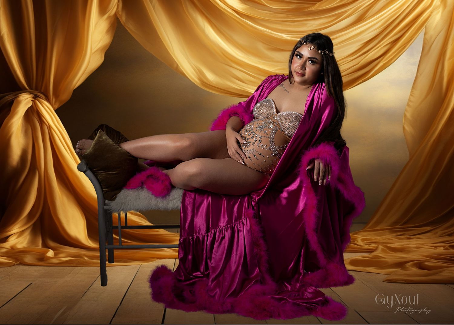 Fashion model in magenta evening gown poses elegantly against golden silk backdrop in artistic photo series.