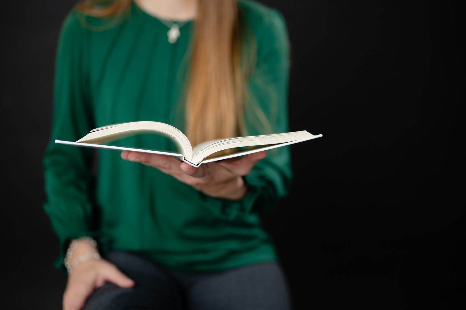 Virtual assistant Heather Scherch of HAS Solutions holds up a copy of the book "Profit First" at the Spring TX studio black background