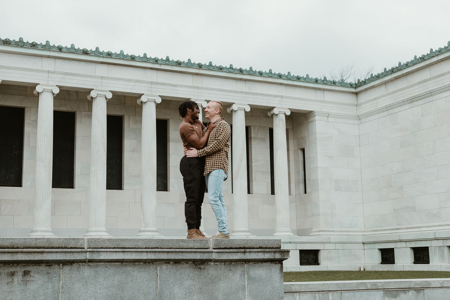 A couple dances together in front of a classical white columned building.