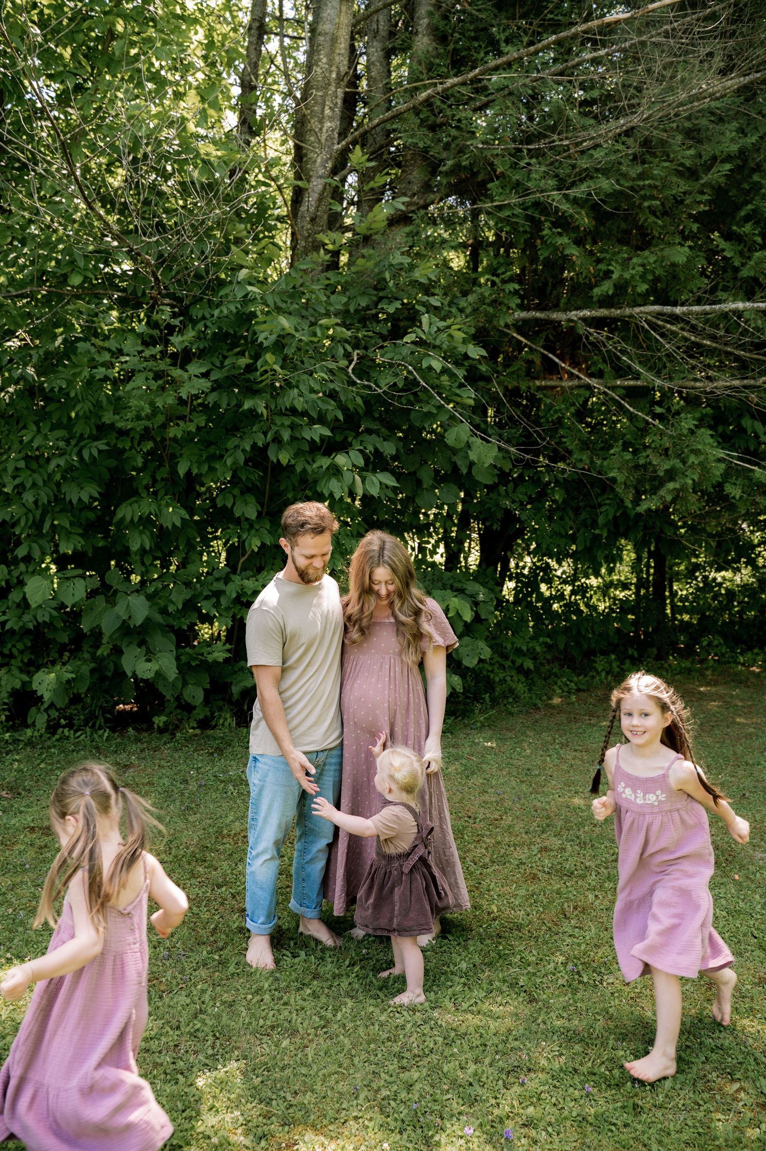 Family jumping and playing together in a grassy field during autumn.