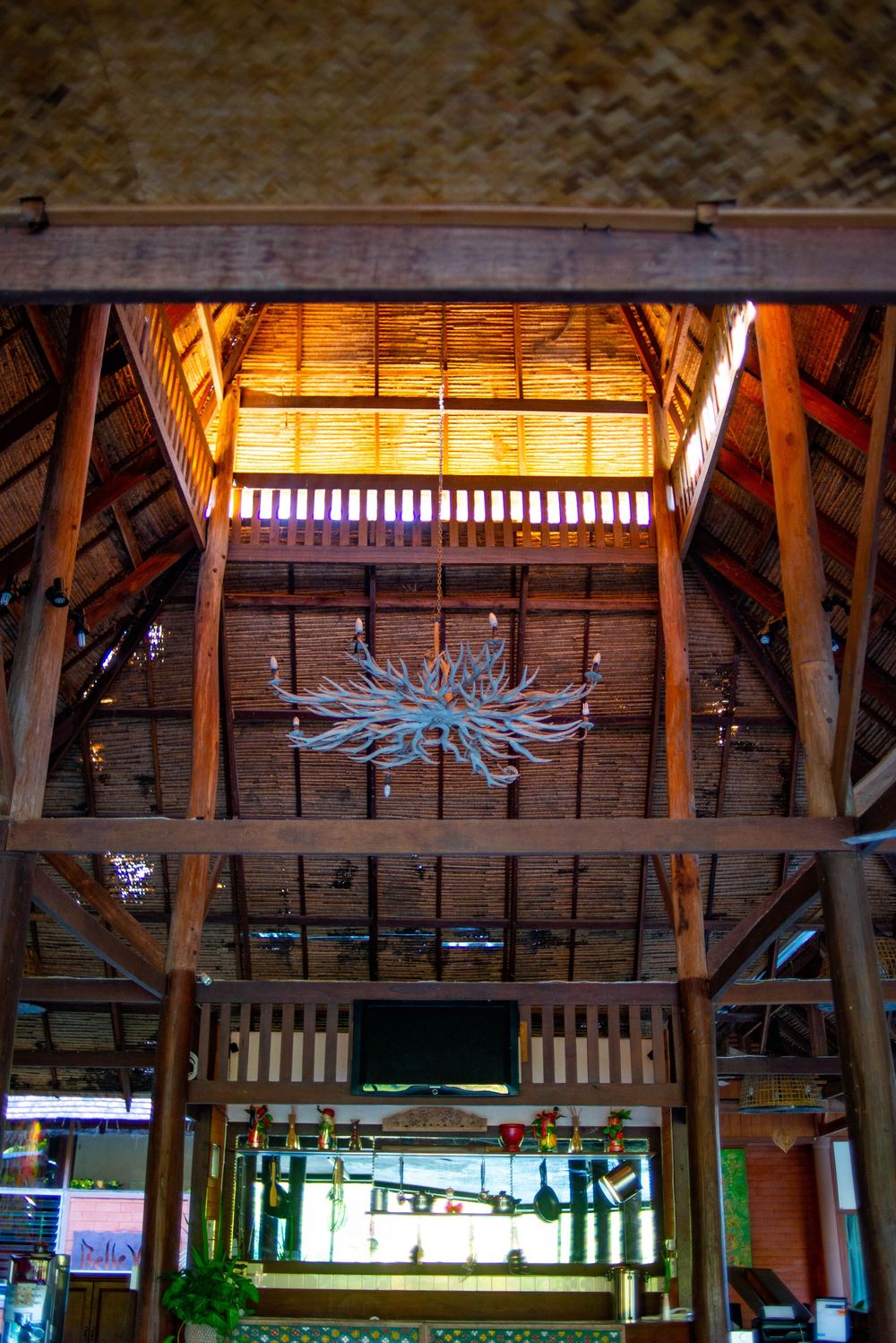 Wooden beams and decorative lighting create a rustic architectural detail in a ceiling structure.