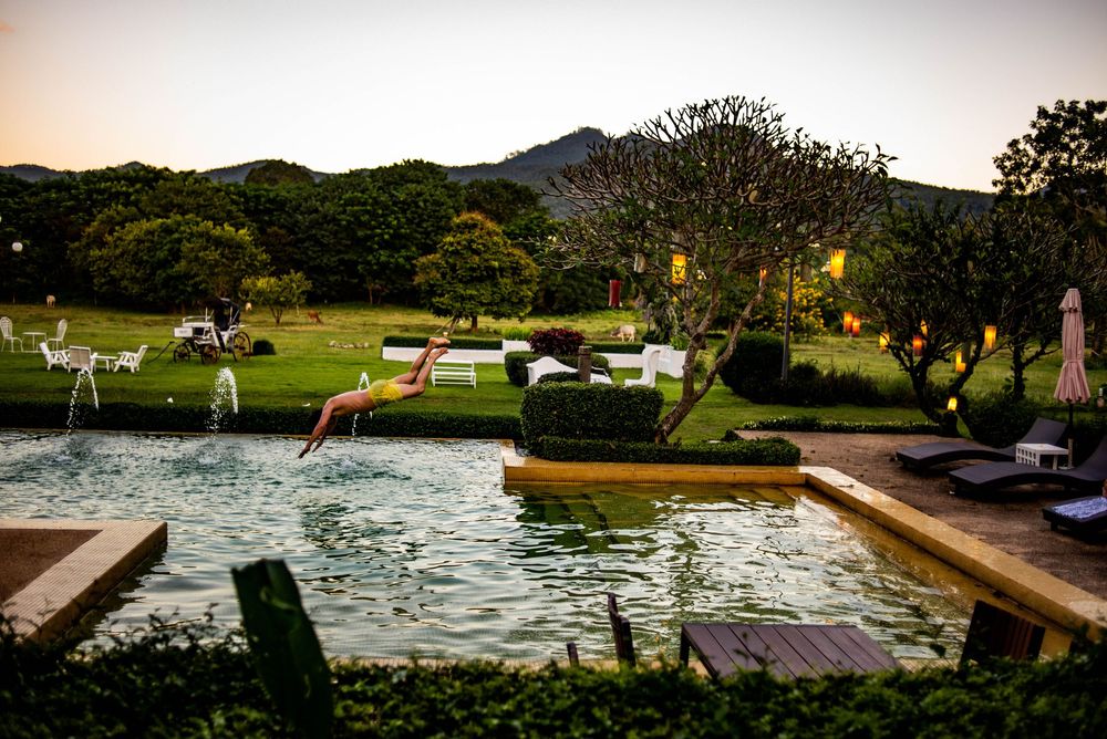 Sunset view of a landscaped resort area with mountains in the background.