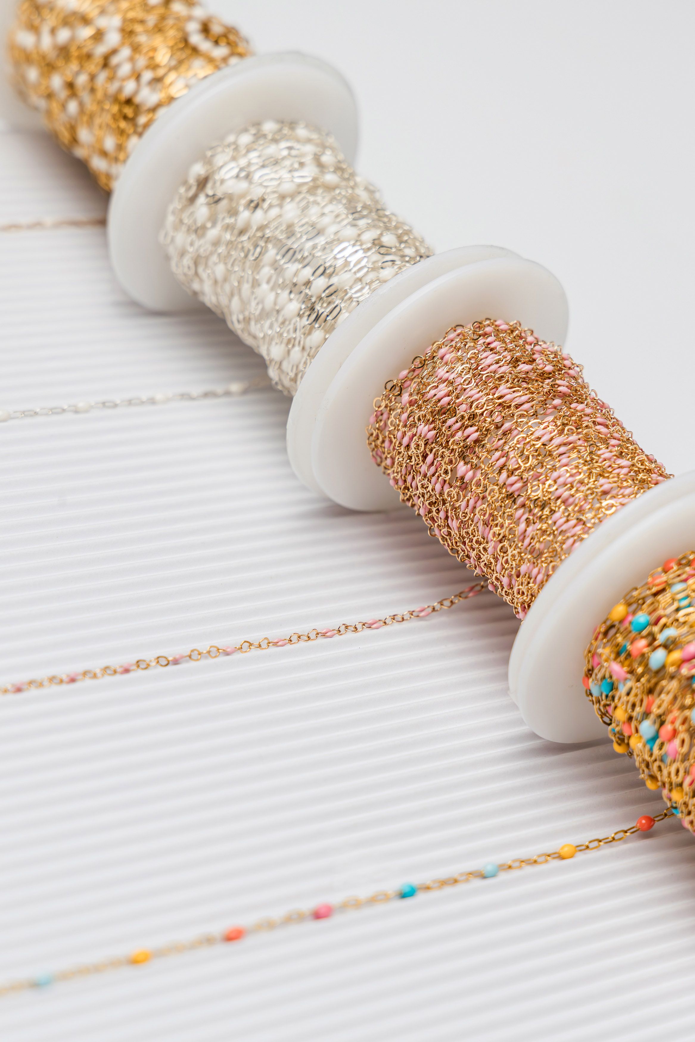 Luxury jewelry chain spools featuring gold silver and enamel chains photographed in Jupiter Florida studio.