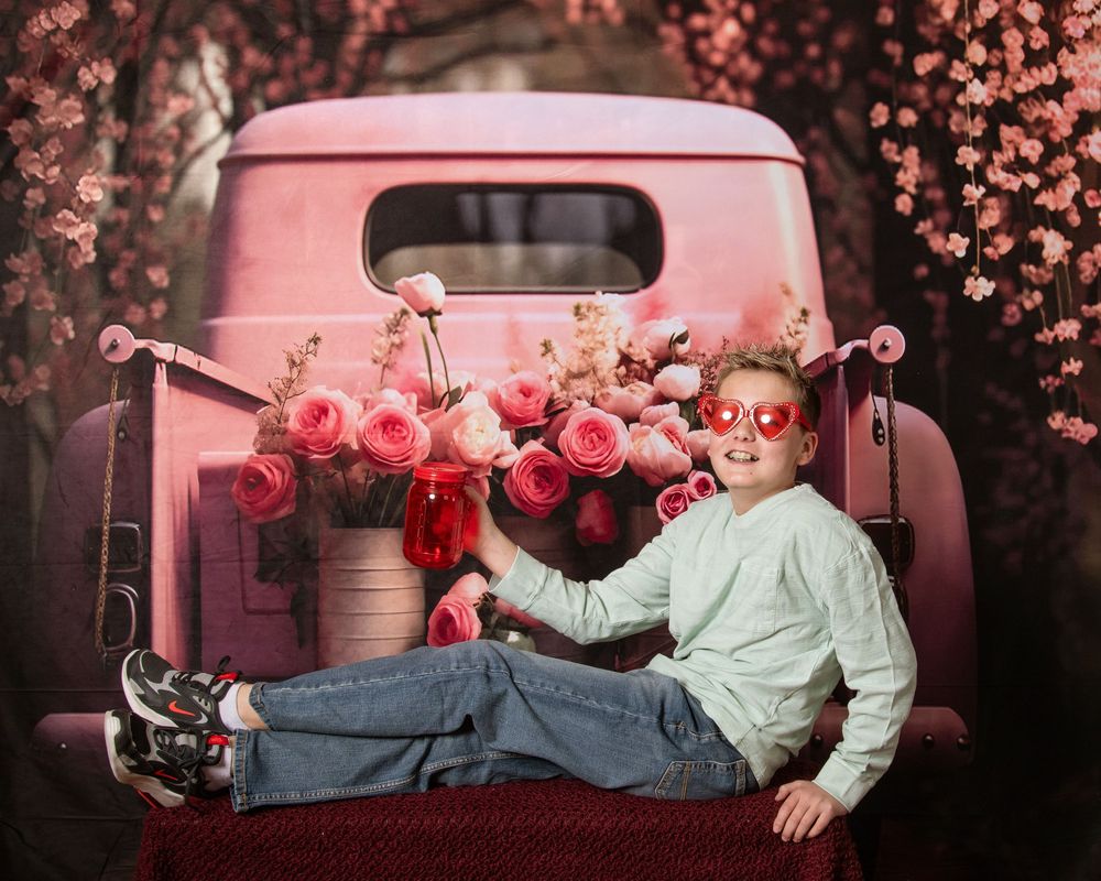 A series of romantic pink-tinted photos showing a couple lounging in the back of a vintage pickup truck at sunset.
