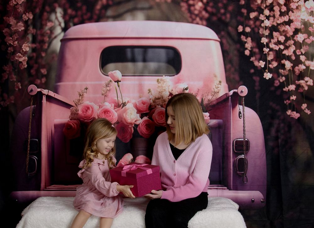 A series of romantic photos showing a couple in pink outfits posing with a vintage car under cherry blossom trees.