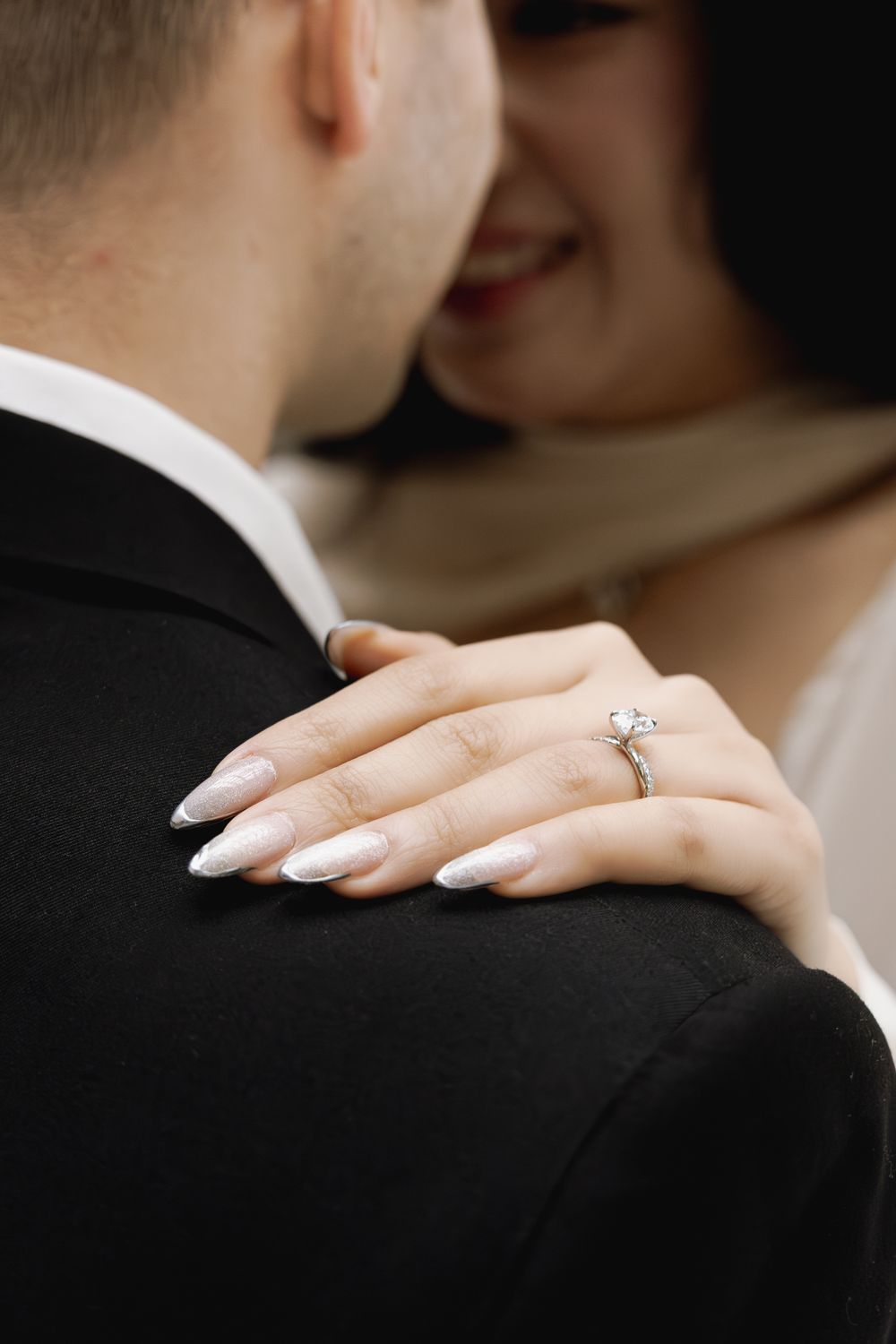 Close-up view of hands with wedding rings embracing during an intimate romantic moment.
