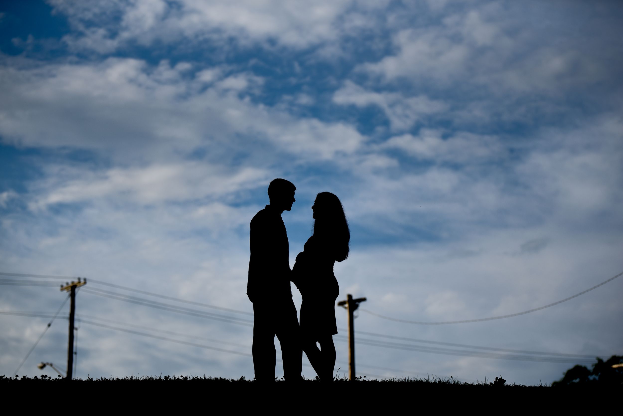 Silhouettes against a blue cloudy sky create a dramatic sunset scene.