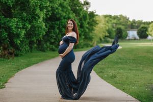 A flowing navy blue fabric billows in the wind during an outdoor photo session.