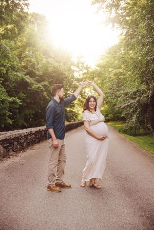Playful dancing sequence on a paved path during golden hour in white summer attire.