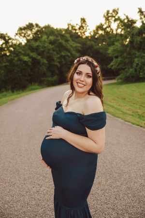 Elegant portrait session on a paved path during golden hour wearing a navy blue dress.