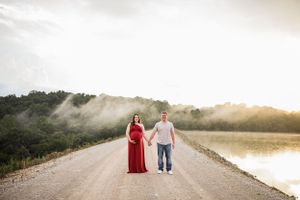A couple walks together on a misty path during golden hour with dramatic lighting.