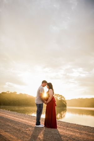 A romantic sunset photoshoot on a beach path shows a couple embracing against the golden sky.