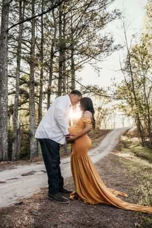 Romantic couple poses in golden sunlight along a tree-lined path in a series of intimate moments.