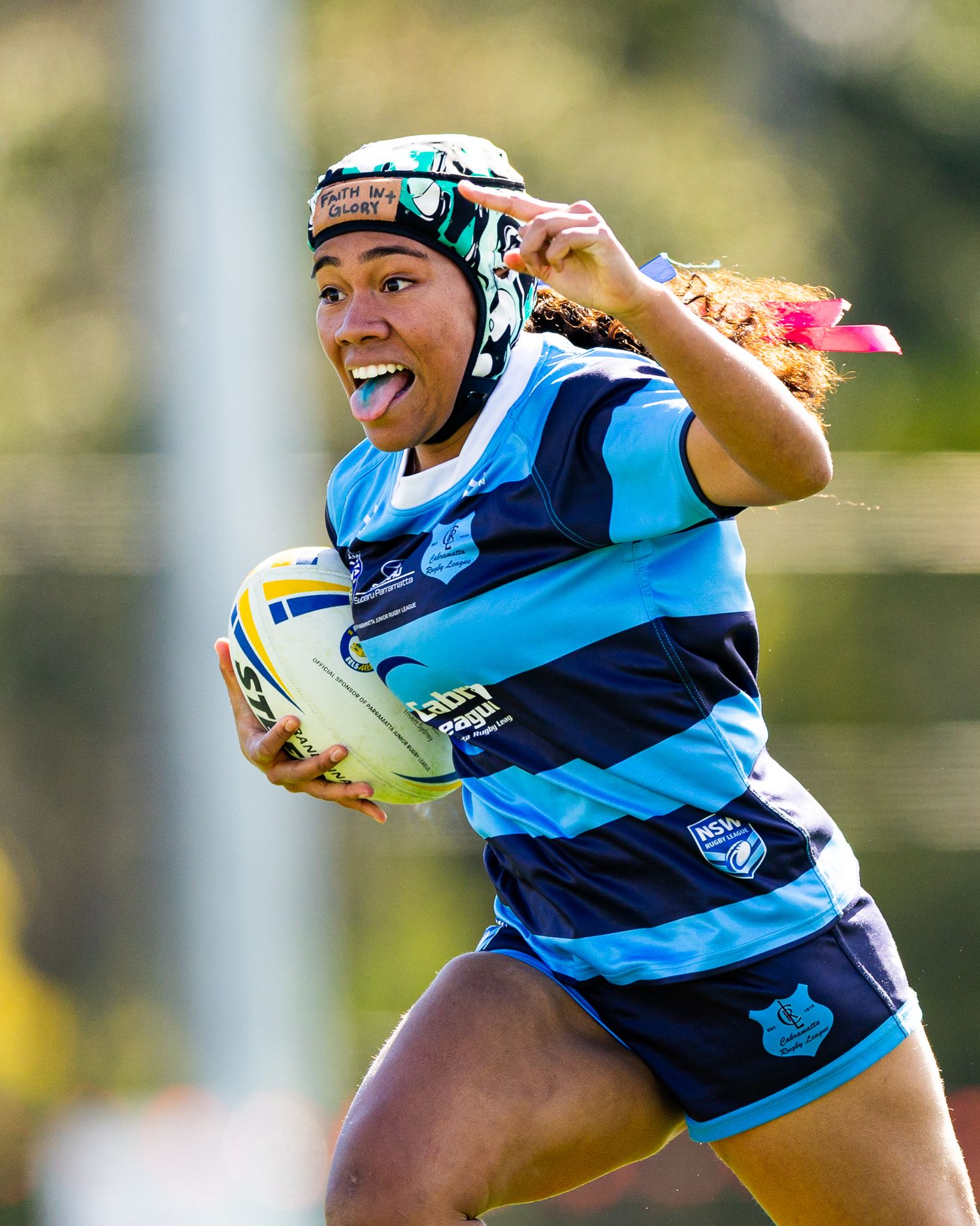 Rugby players in striped blue uniforms running with the ball during a match.