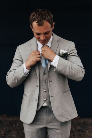 A gentlemen fixes his tie