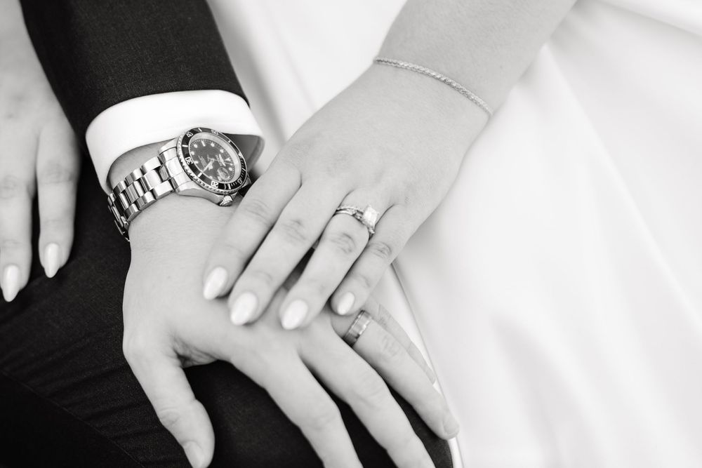 Three close-up shots of wedding rings and hands displayed side by side in black and white.