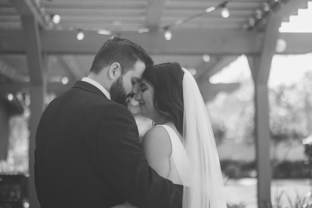 A tender black and white moment between two people sharing an intimate embrace on their wedding day.