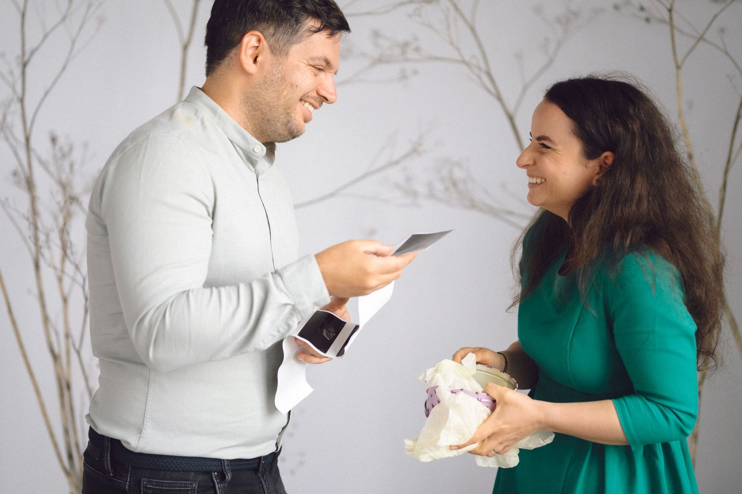 Two people engaged in playful conversation against a marble wall background.