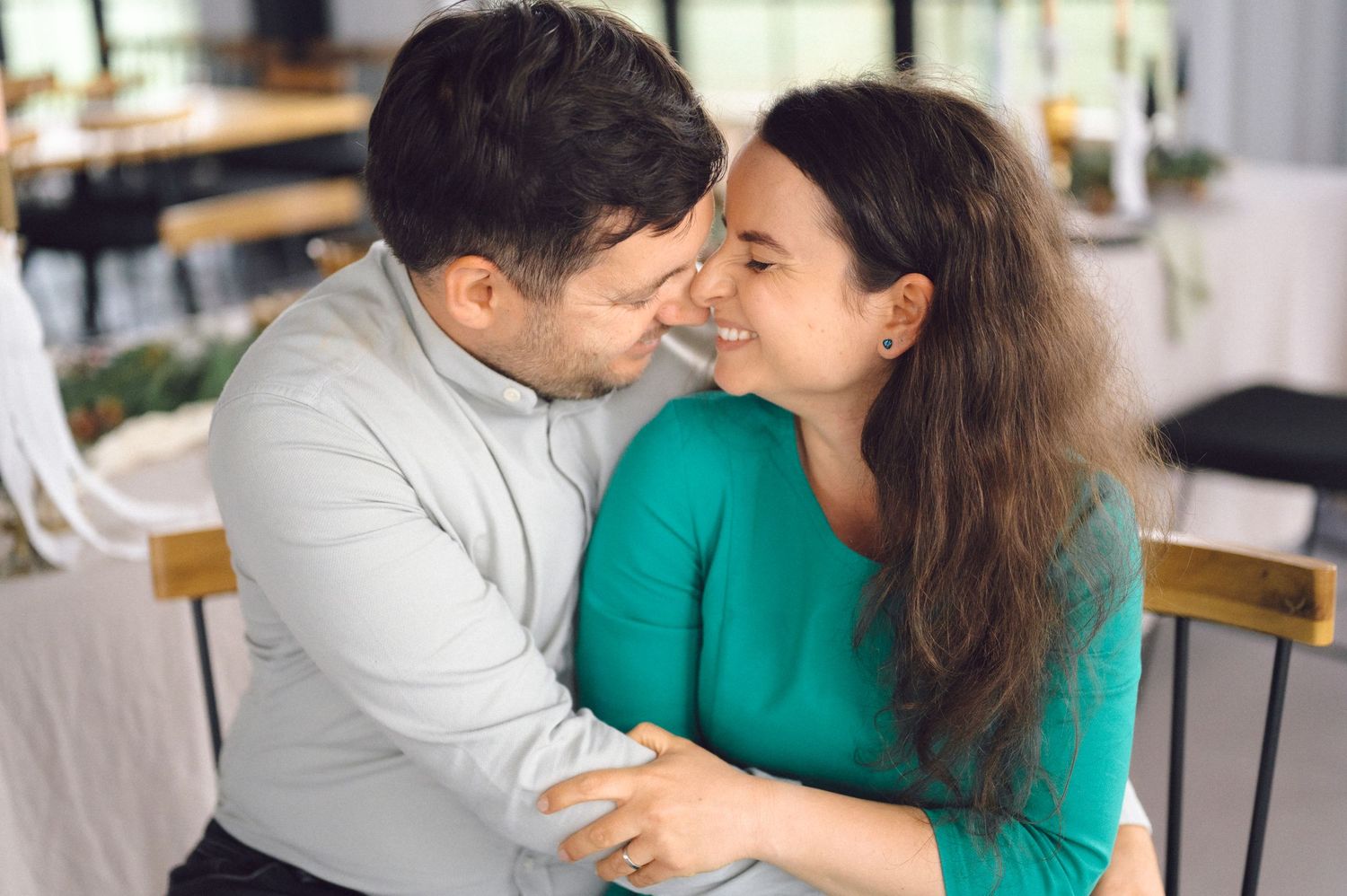A loving couple sharing an intimate moment while sitting together at a restaurant.
