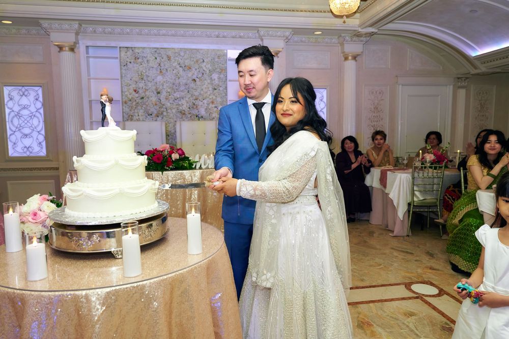 An elegant wedding reception hall with white decor and a tiered wedding cake display. at Jericho Terrace