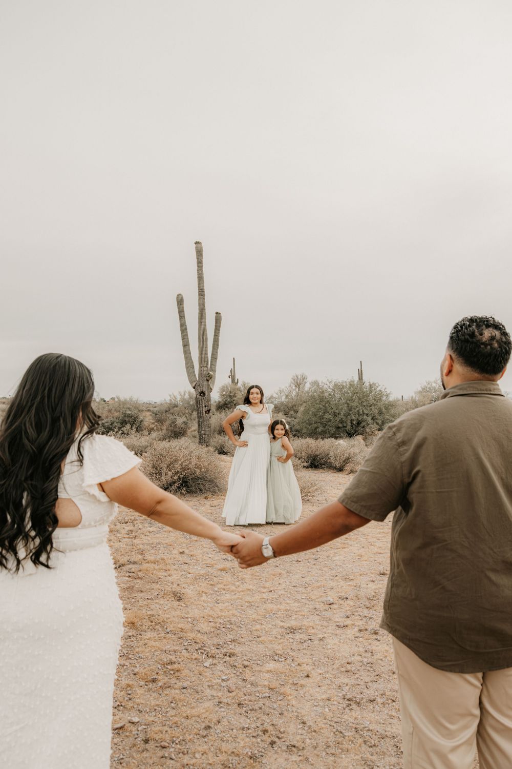 Family holding hands together during a warm desert session in Arizona.