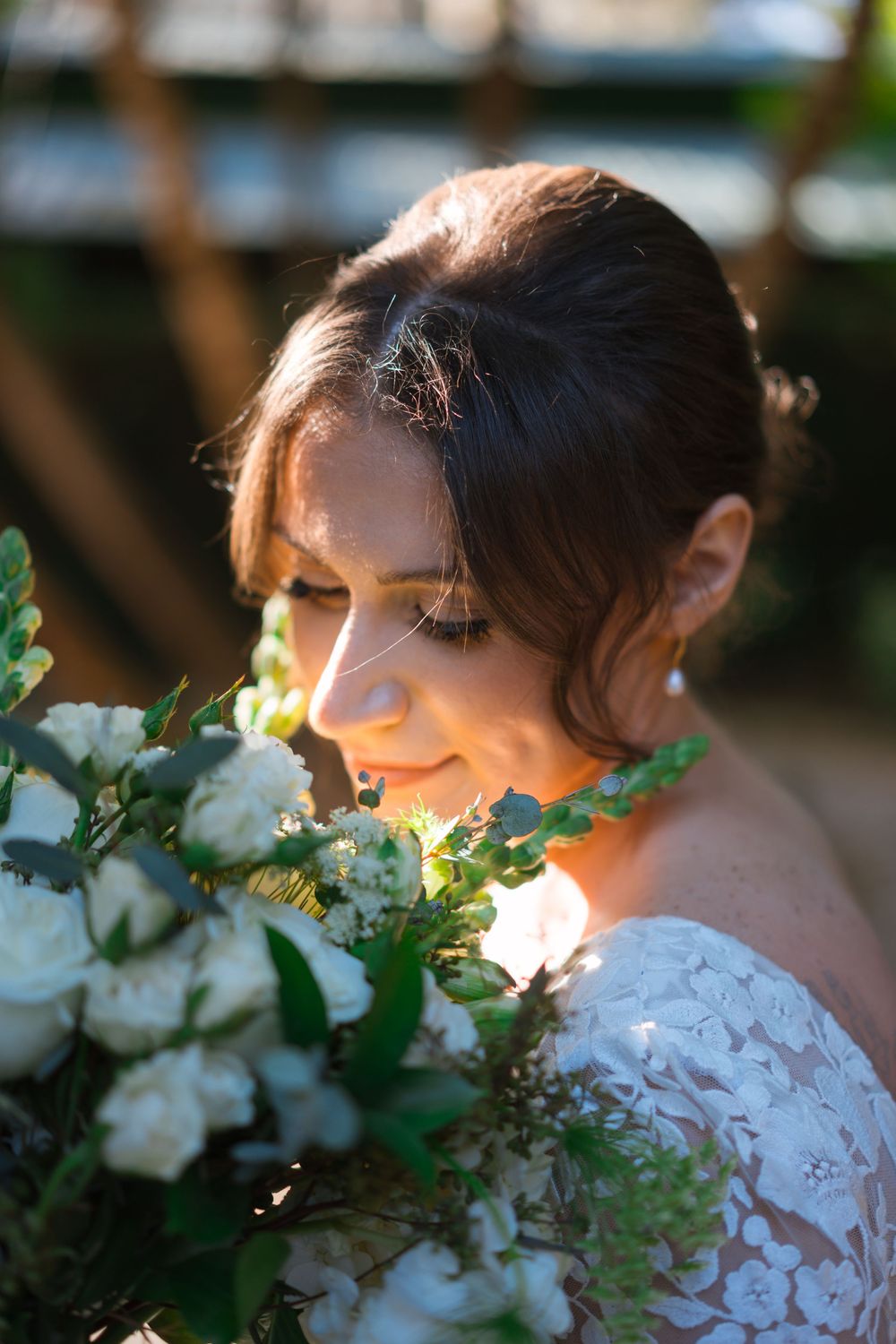 A romantic bridal portrait series in white lace with delicate flowers and golden sunlight creating an ethereal mood.
