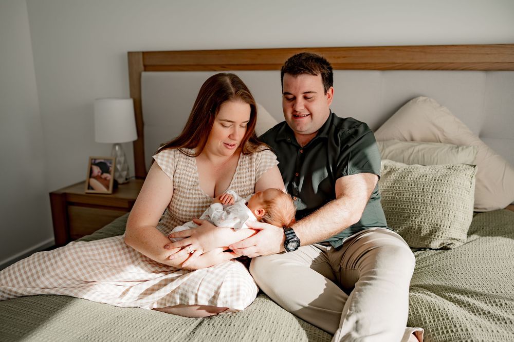 A series of tender lifestyle photographs showing parents bonding with their baby on a cozy bed.