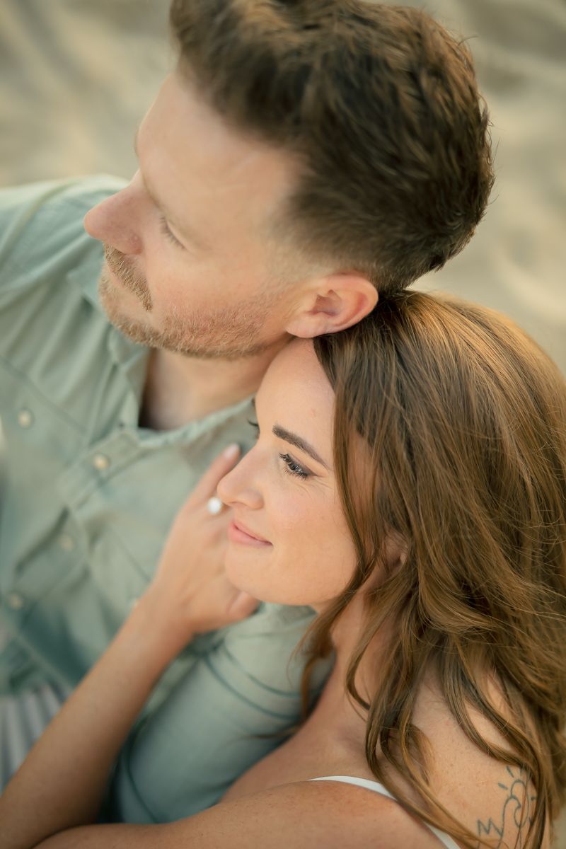 Tender moment captured between couple in warm sunset lighting.