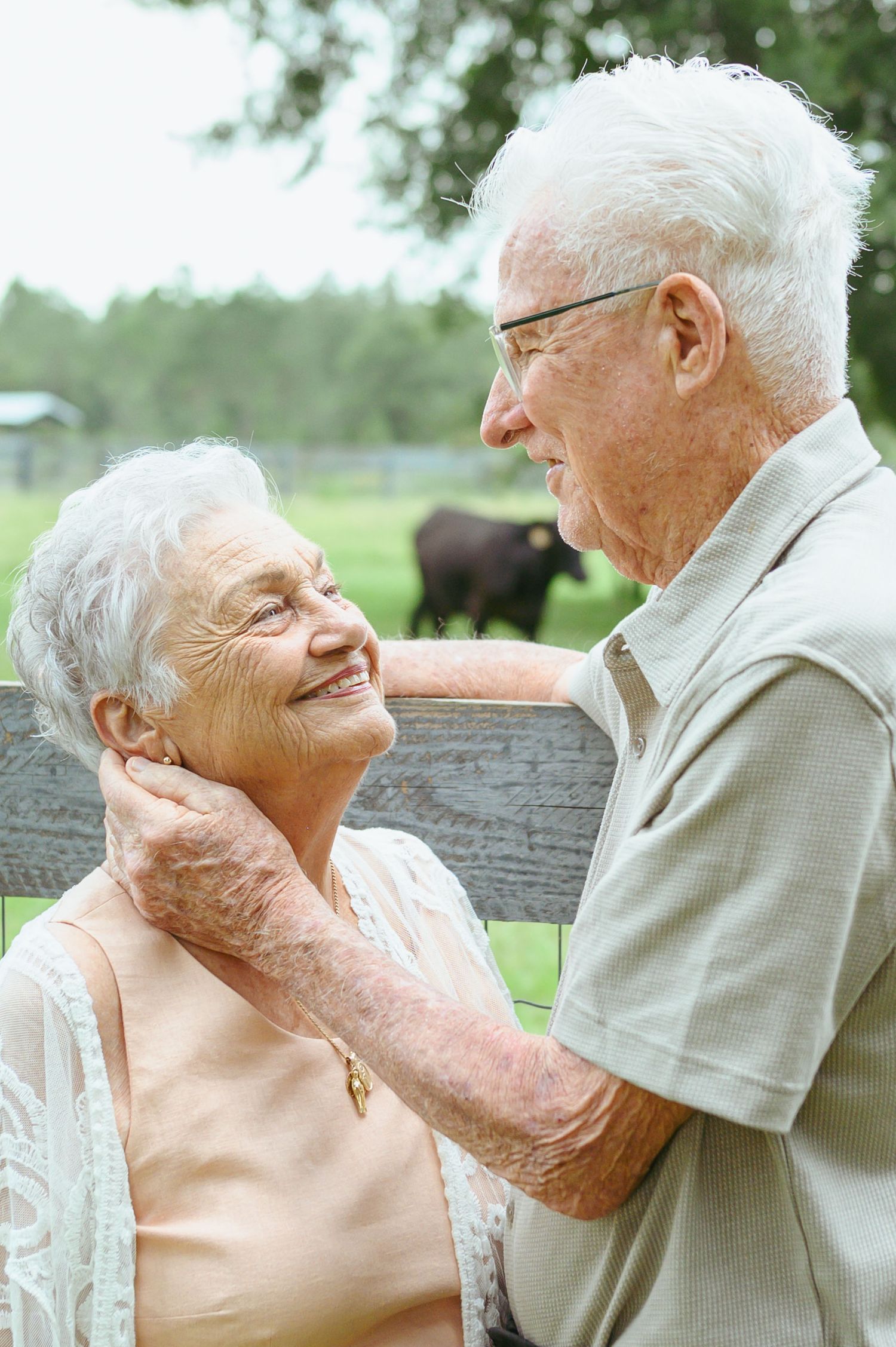 Elderly couple shares tender moment outdoors, showing enduring love and affection.