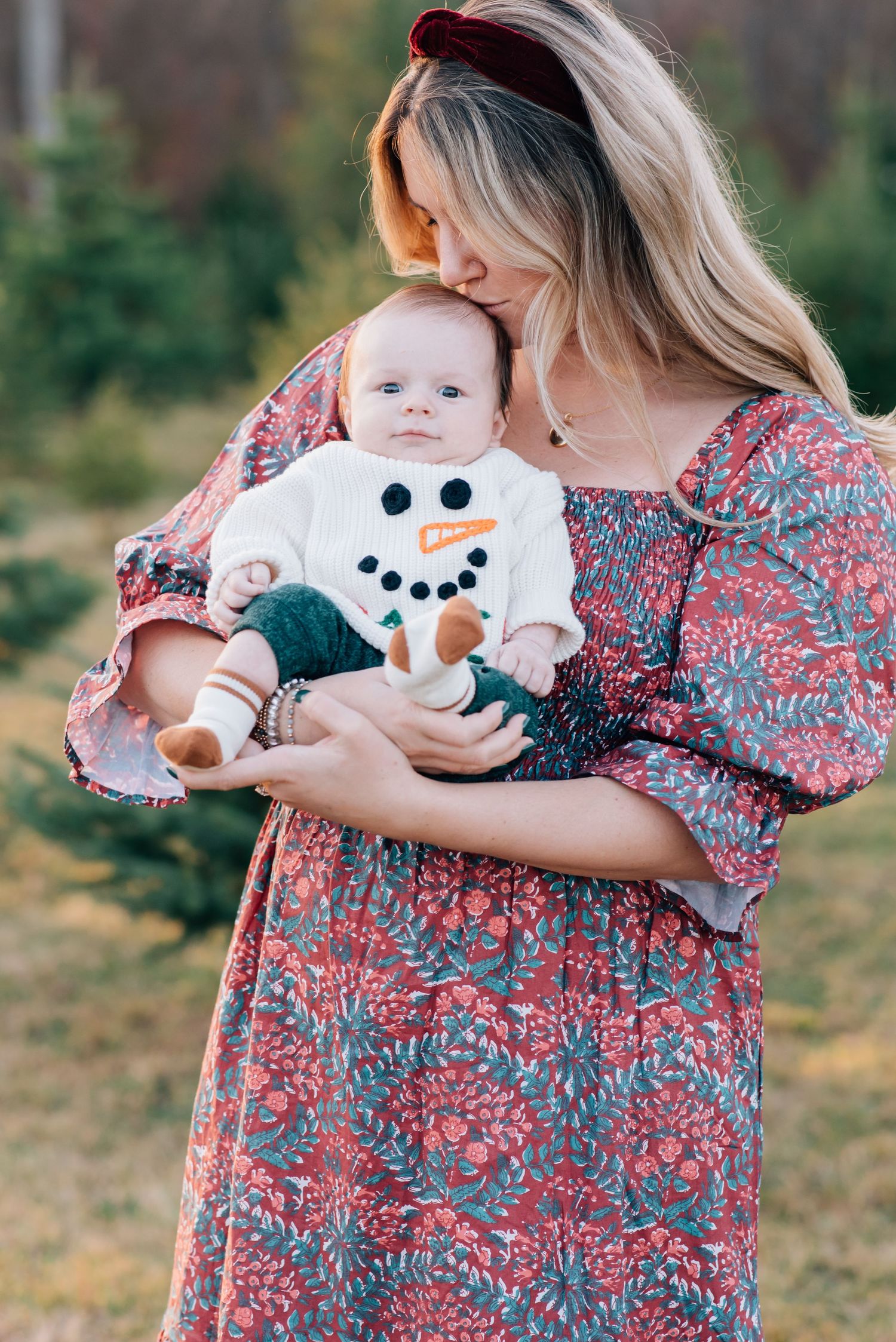 A newborn boy smiles at the camera during a Christmas mini session in Monmouth county nj.