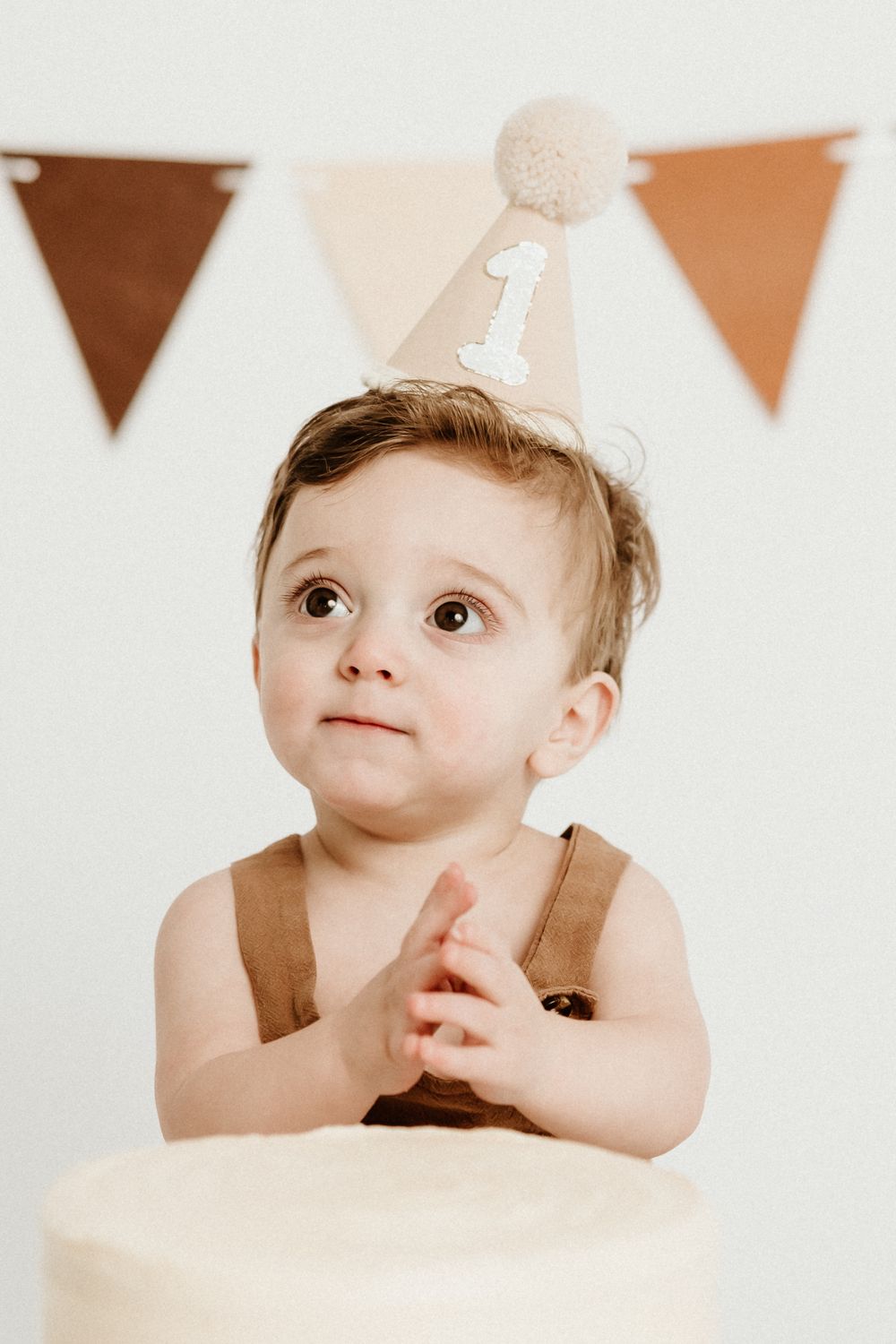 Collage of four photos showing a young child looking upward with brown bunting decorations visible in the background.
