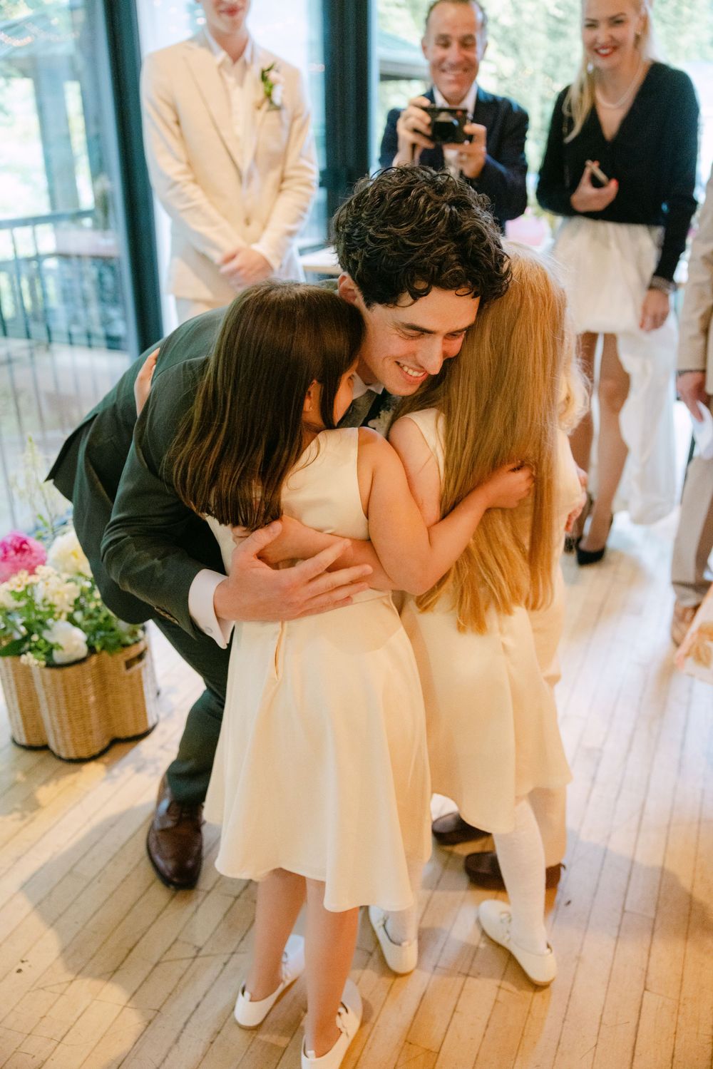 A sweet sequence shows a couple sharing intimate dance moves in a light-filled room with guests watching nearby.