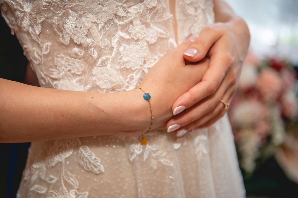 Close up details of delicate white lace and ribbon being laced up on an elegant bridal gown or corset.