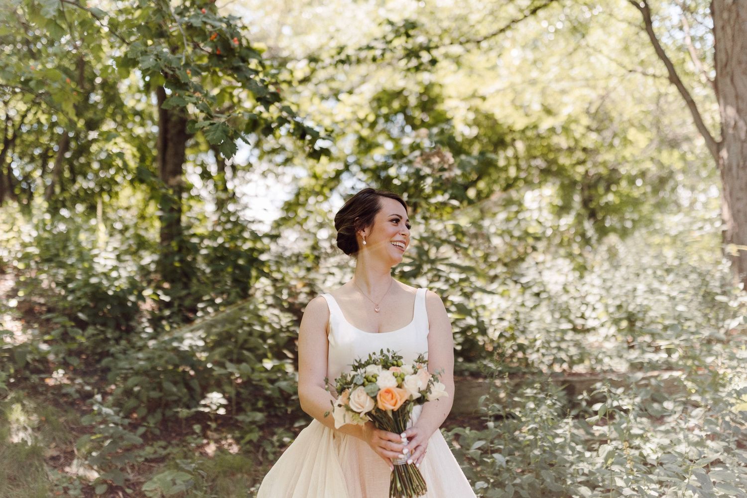 Soft natural lighting illuminates a bridal portrait session in a lush outdoor garden setting.