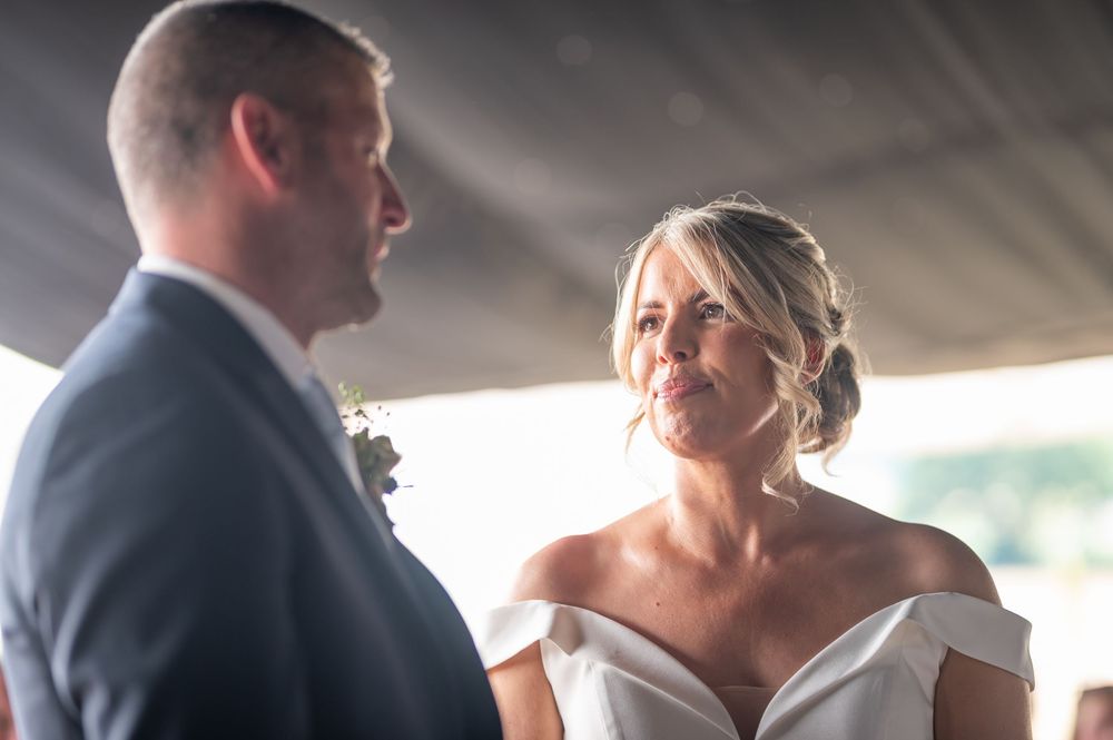 Wedding couple sharing an intimate moment under a white tent.