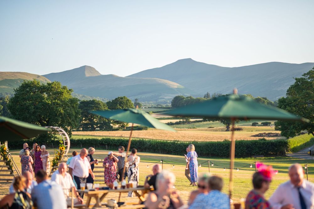 Panoramic view of mountains and countryside with wedding tent in the distance.