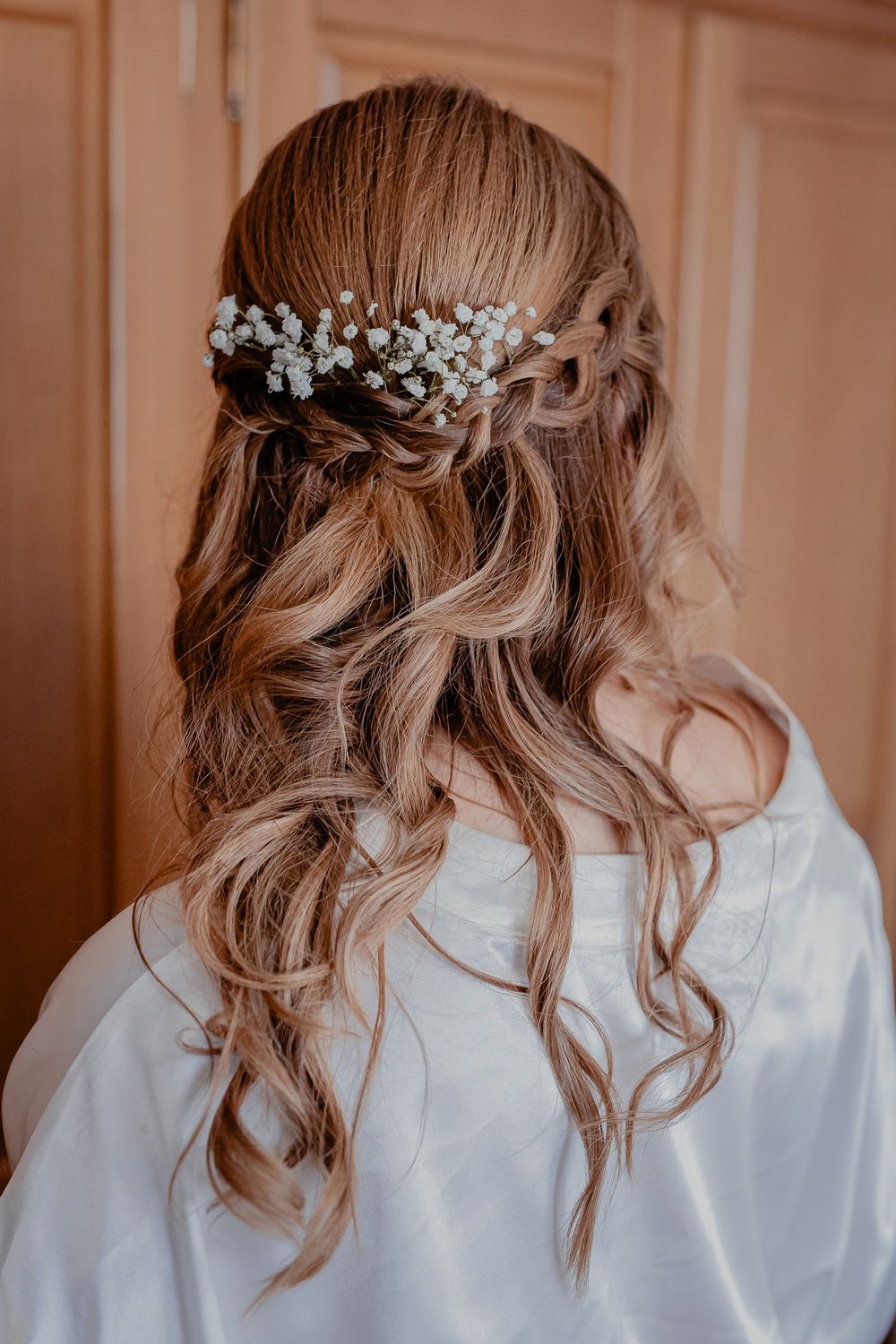 Elegant bridal hairstyle with pearl accessories and soft curls cascading down.