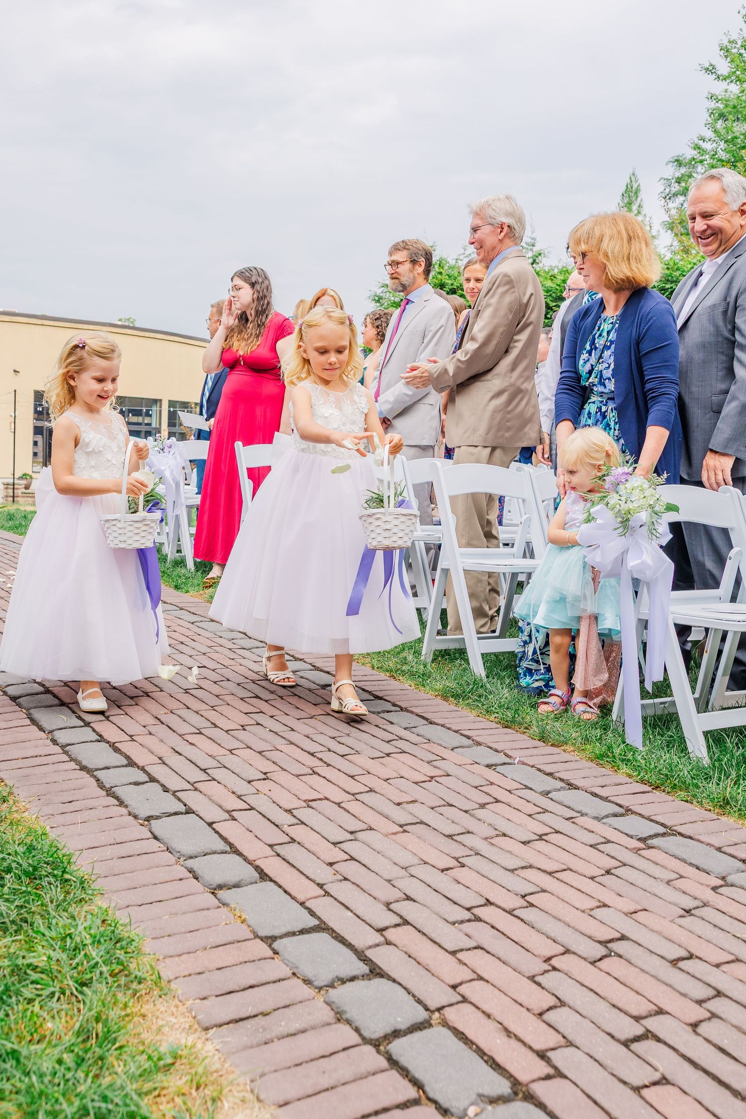 Wedding photos of happy moments captured along a brick pathway surrounded by lush garden landscaping and trees.