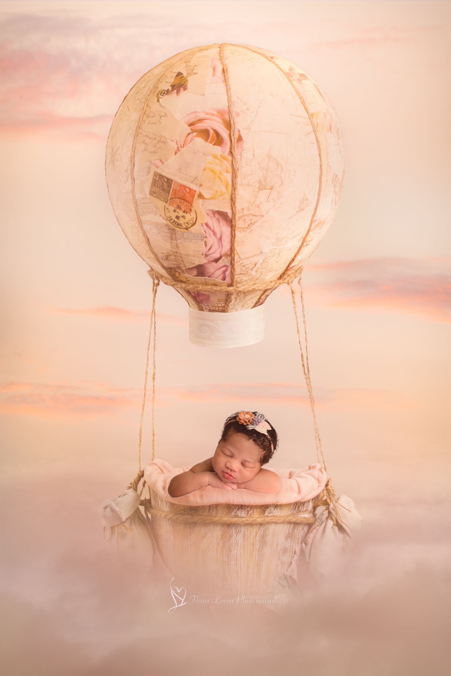 Dreamy newborn photography setup with paper lantern hot air balloon props in soft pink ethereal lighting.