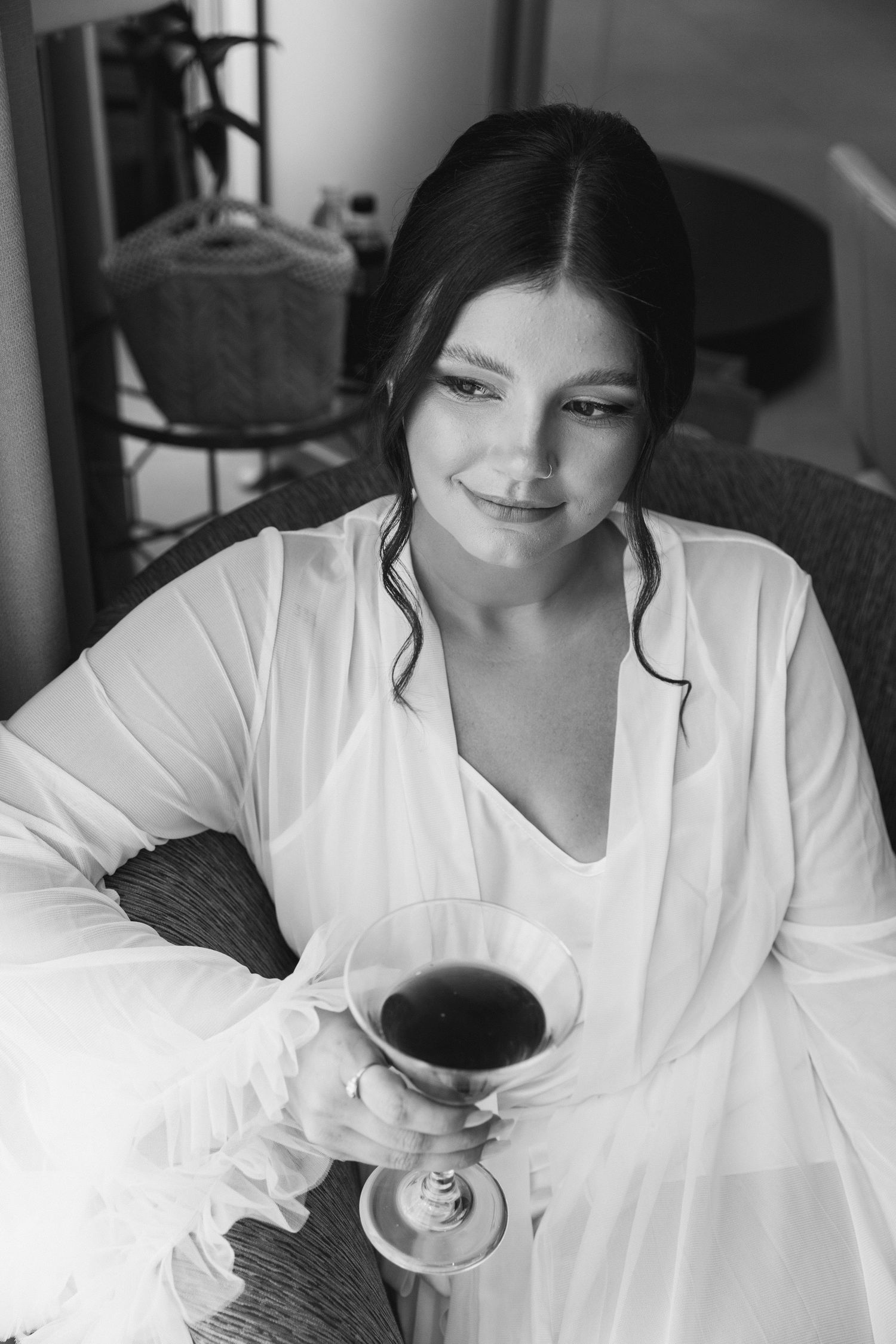 Woman in white button down shirt enjoying coffee and conversation in black and white portrait series.