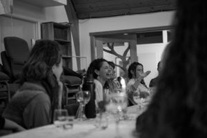 Guests seated at a long table during an indoor social gathering.