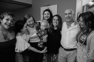 A cheerful group of people gather close together for a black and white photograph.
