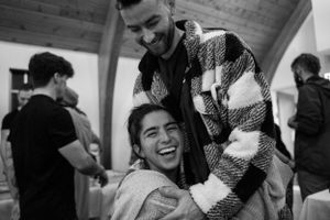 Two people sharing a joyful moment at an indoor gathering.