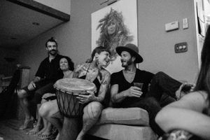 Friends share laughs and music during an intimate home gathering with percussion instruments.