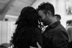 An intimate black and white moment between two people sharing a close embrace.