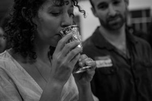 Someone drinking from a ceremonial cup in a black and white photograph.