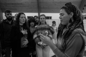 People gather in a circle during what appears to be a spiritual or ceremonial moment.