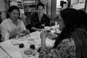 People enjoying a meal together at a dining table with drinks and plates.