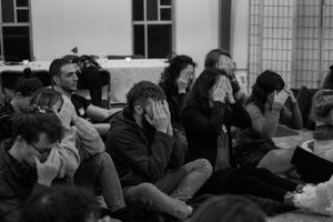 Audience members watch intently during an emotional performance or presentation.