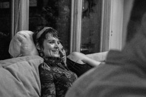 A black and white photo showing someone relaxing on a couch with a joyful expression.